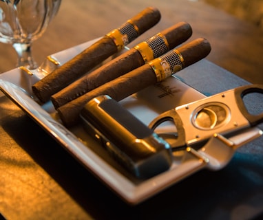 three cigar beside cutter on ashtray