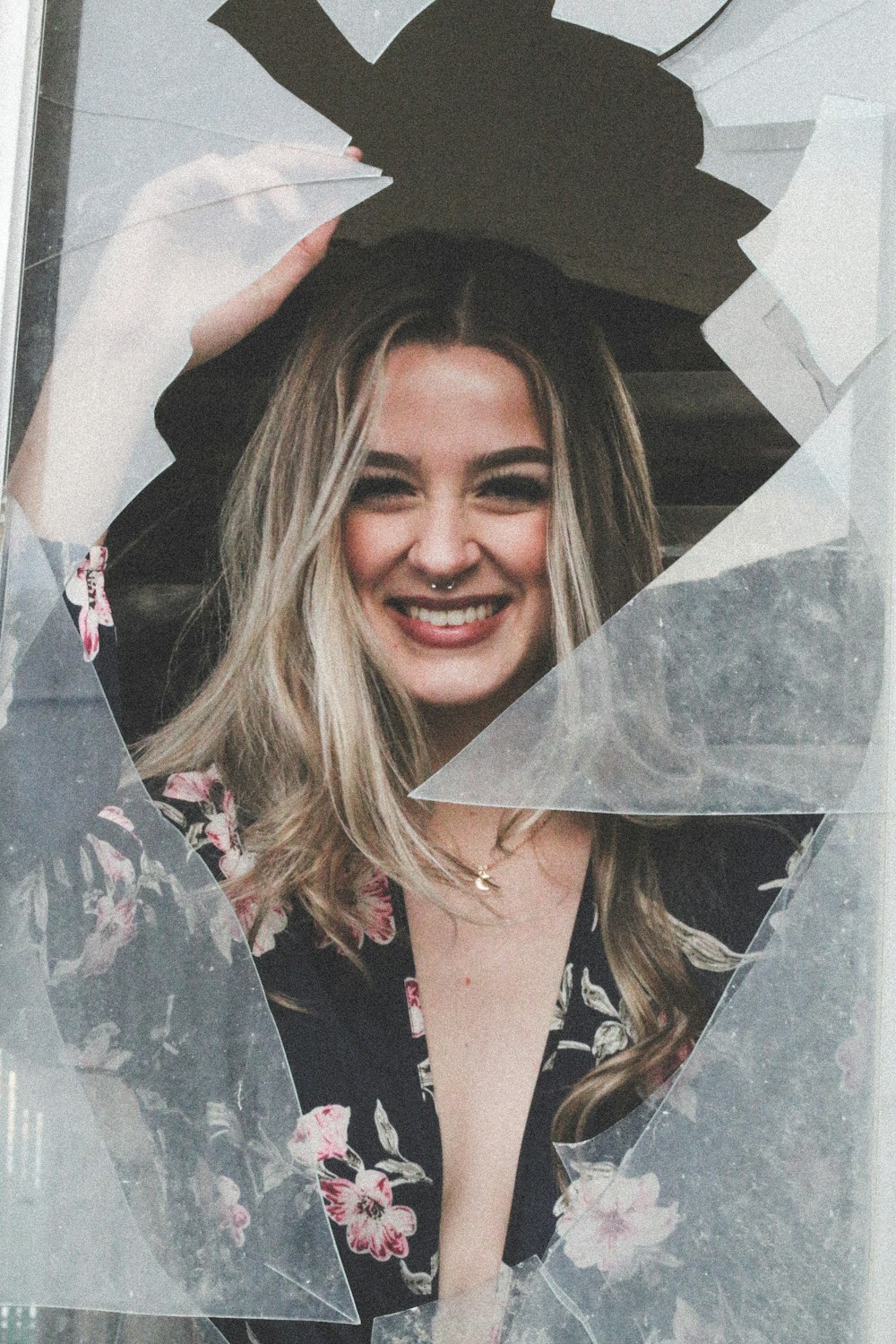 smiling woman wearing black and pink floral dress