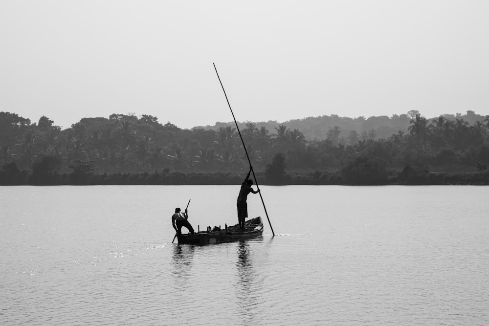 two men on boat at middle of sea