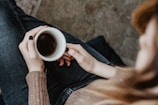 A close-up of hands holding a coffee cup during a discussion.