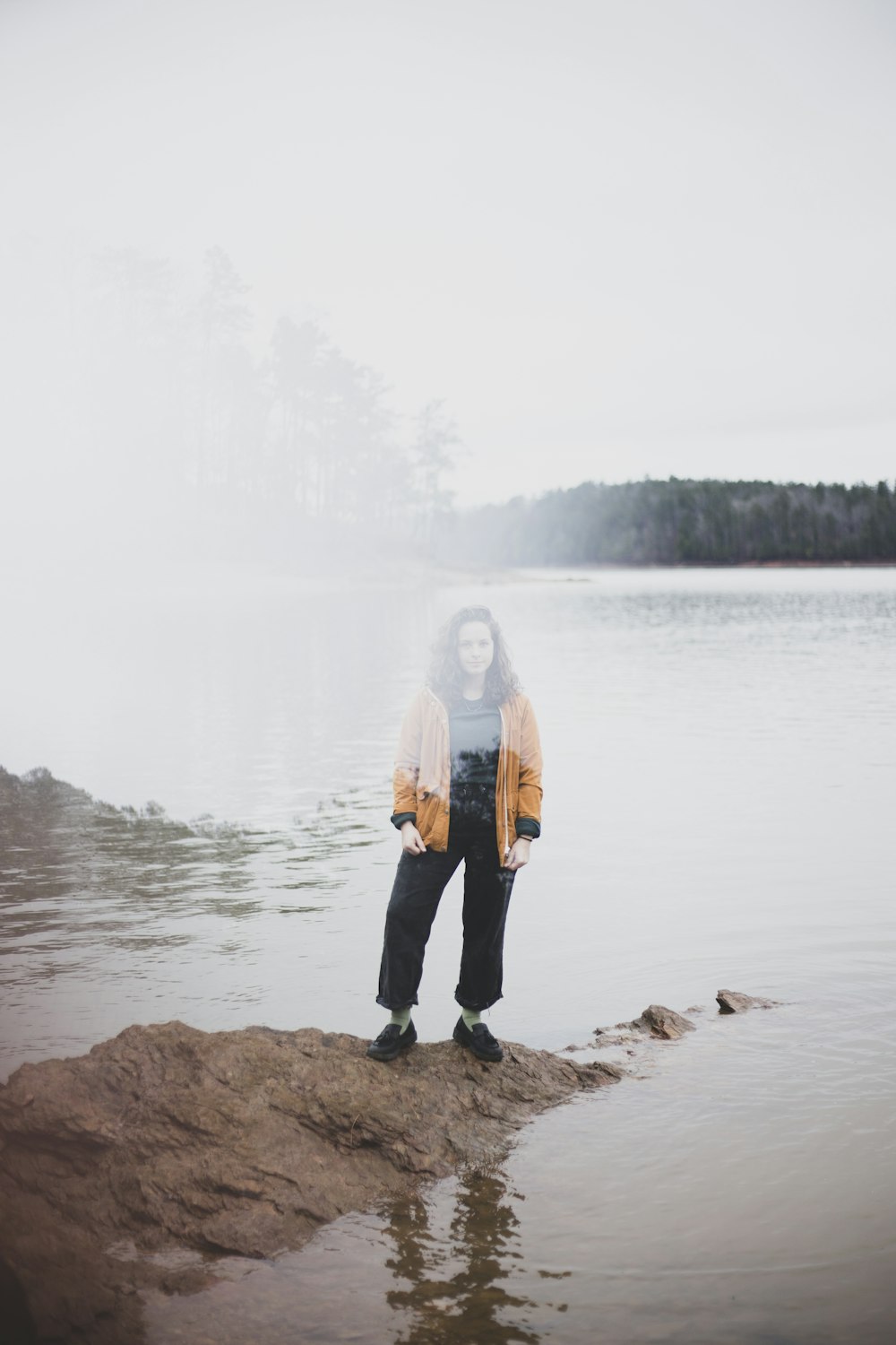 woman standing on rock formation beside sea