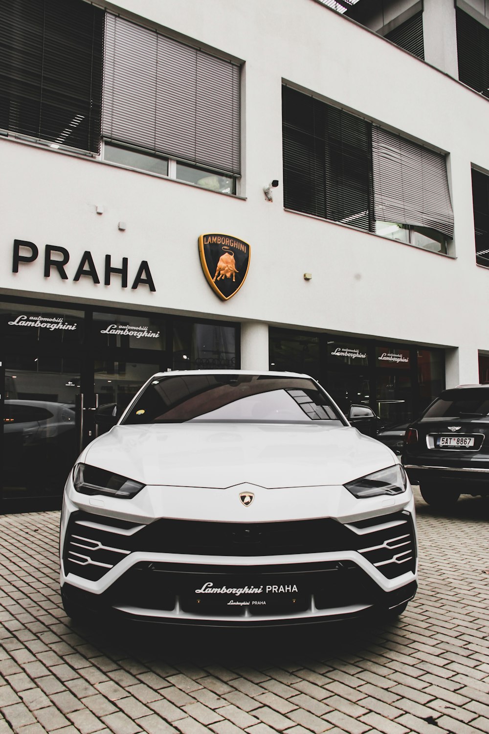 Lamborghini Praha bianca parcheggiata fuori dal negozio