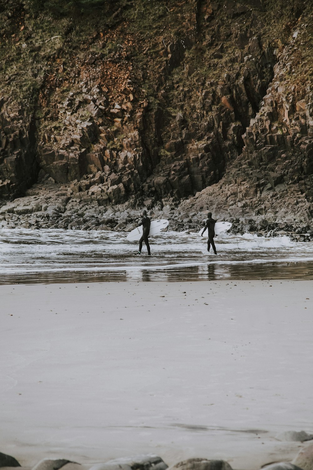 surfers by shore during daytime