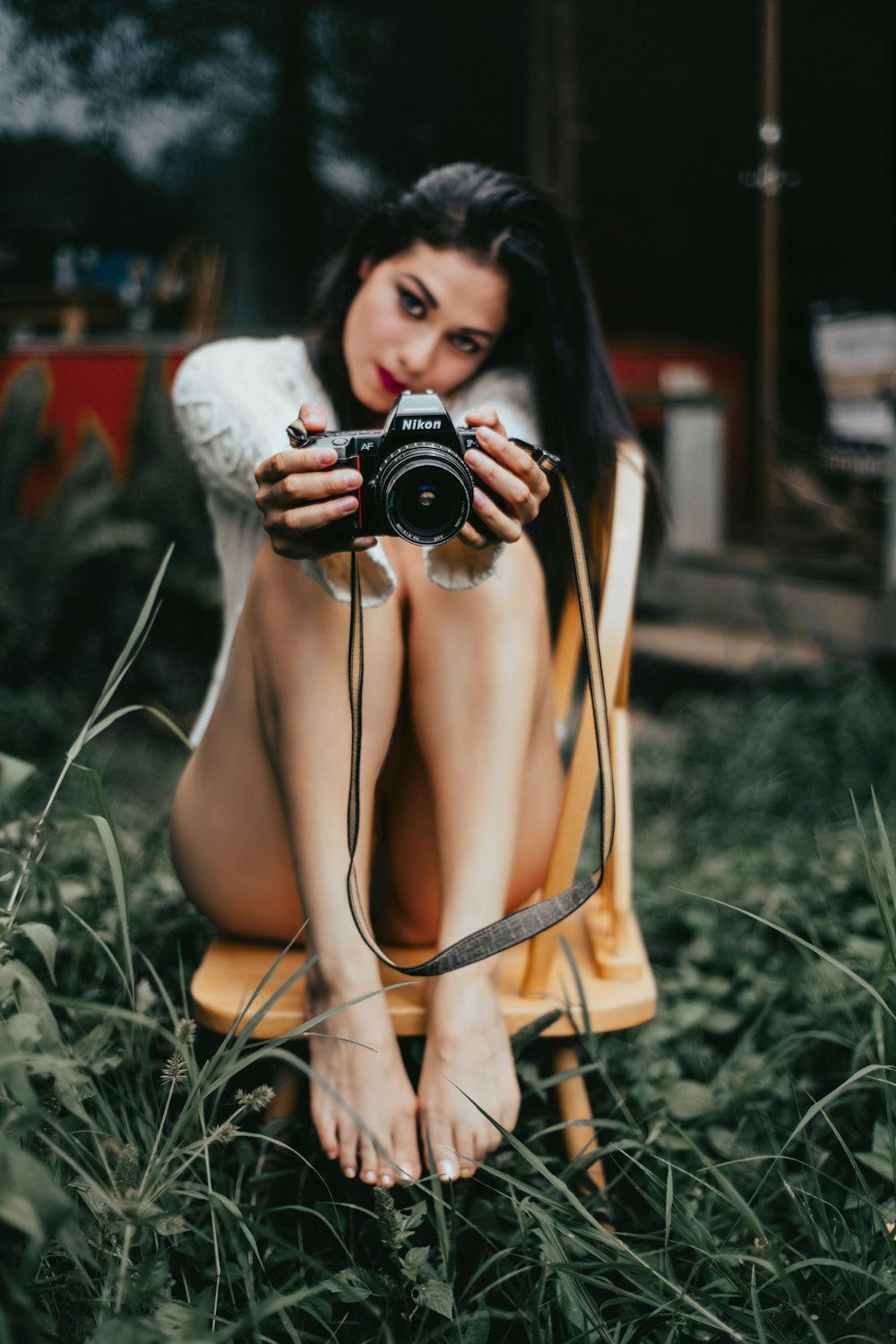 sitting woman on chair holding black camera