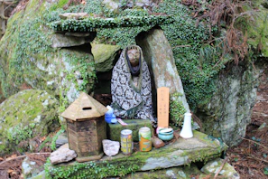 A tranquil outdoor altar adorned with candles, flowers, and sacred stones.