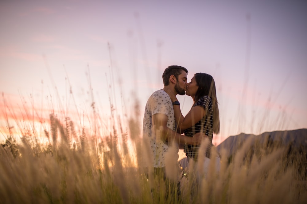 芝生の上でキスをするカップル