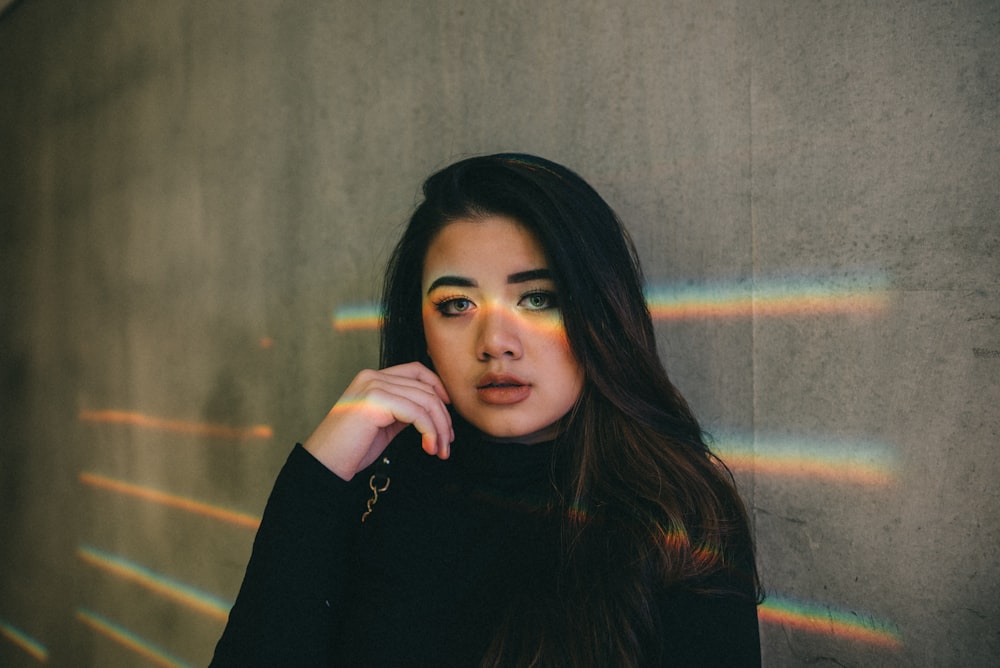 woman in black top leaning on wall