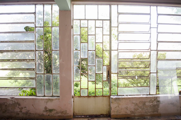 Panoramic shot of a bright room with multiple PVC windows opening to a garden.
