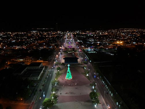 An aerial view of a neighborhood illuminated with vibrant Christmas lights.