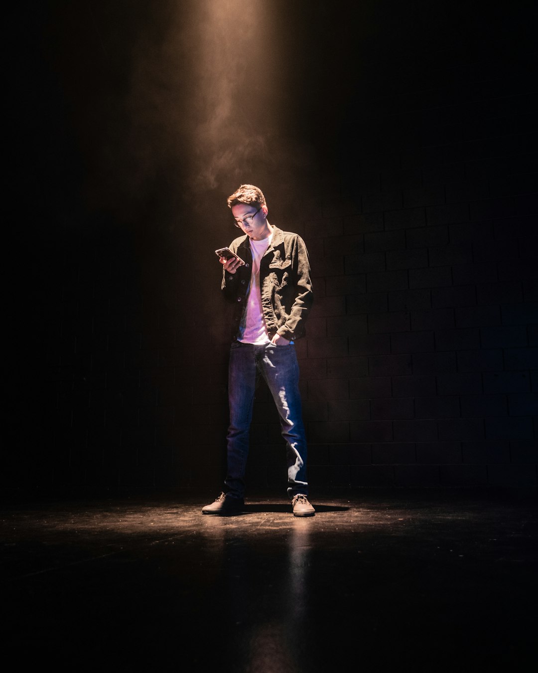  man standing on spotlight using smartphone pot container utensils