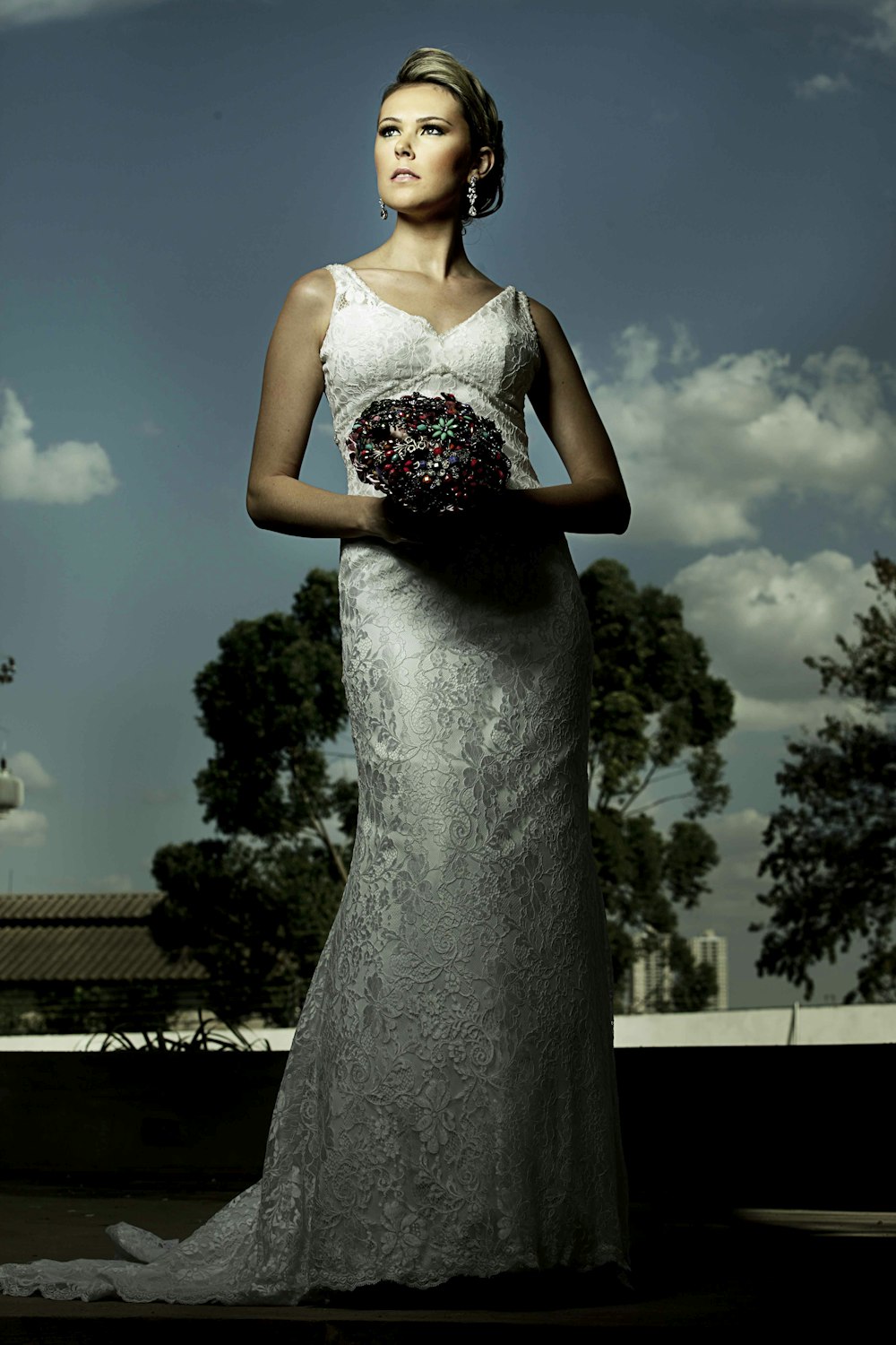 mujer con vestido de novia blanco sosteniendo ramo de flores