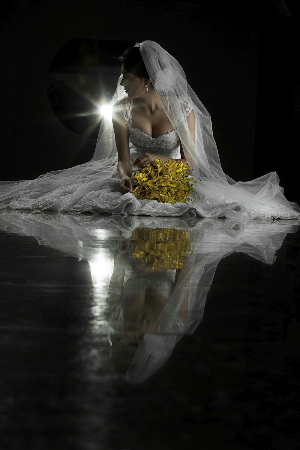 woman in white sleeveless wedding dress holding yellow bouquet of flowers