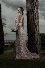 woman in gray glitter gown standing beside tree
