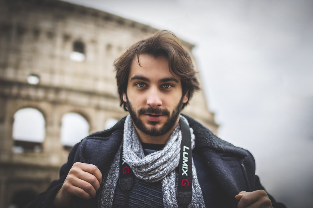 man wearing black jacket standing near Colosseum