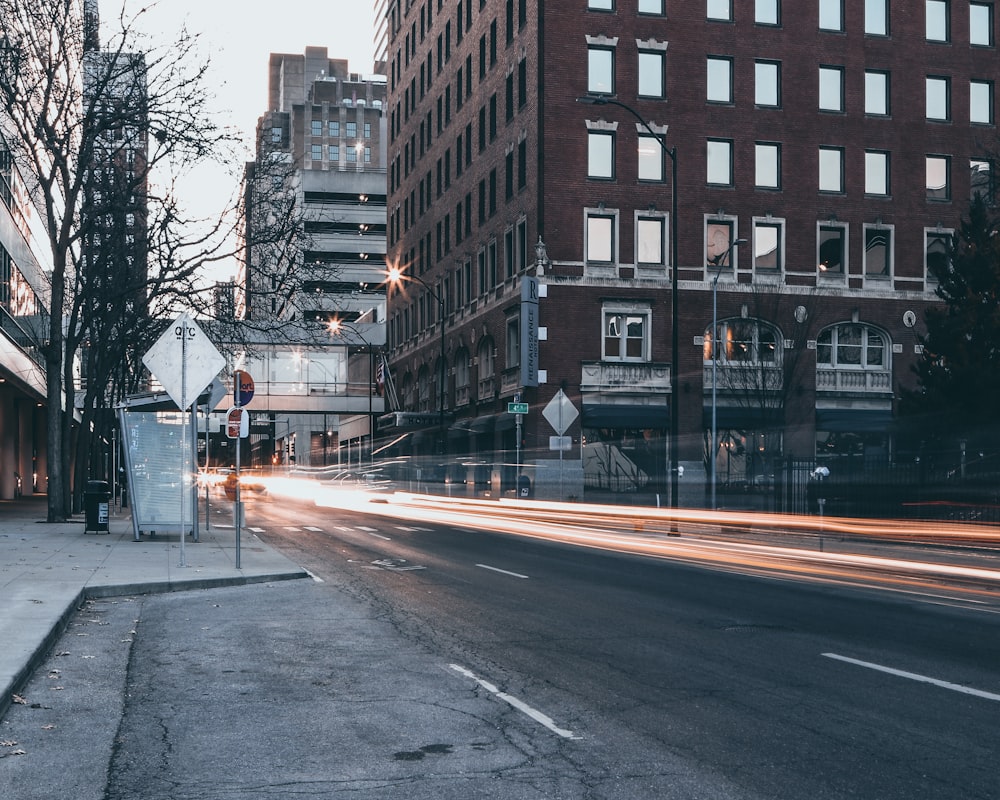 gray pavement road beside high rise building