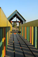 Technician assembling a colorful kidplay structure outdoors.