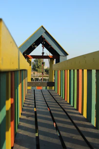 Colorful kidplay structure being assembled by skilled workers outdoors.