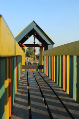A friendly technician assembling a colorful kidplay structure outdoors.