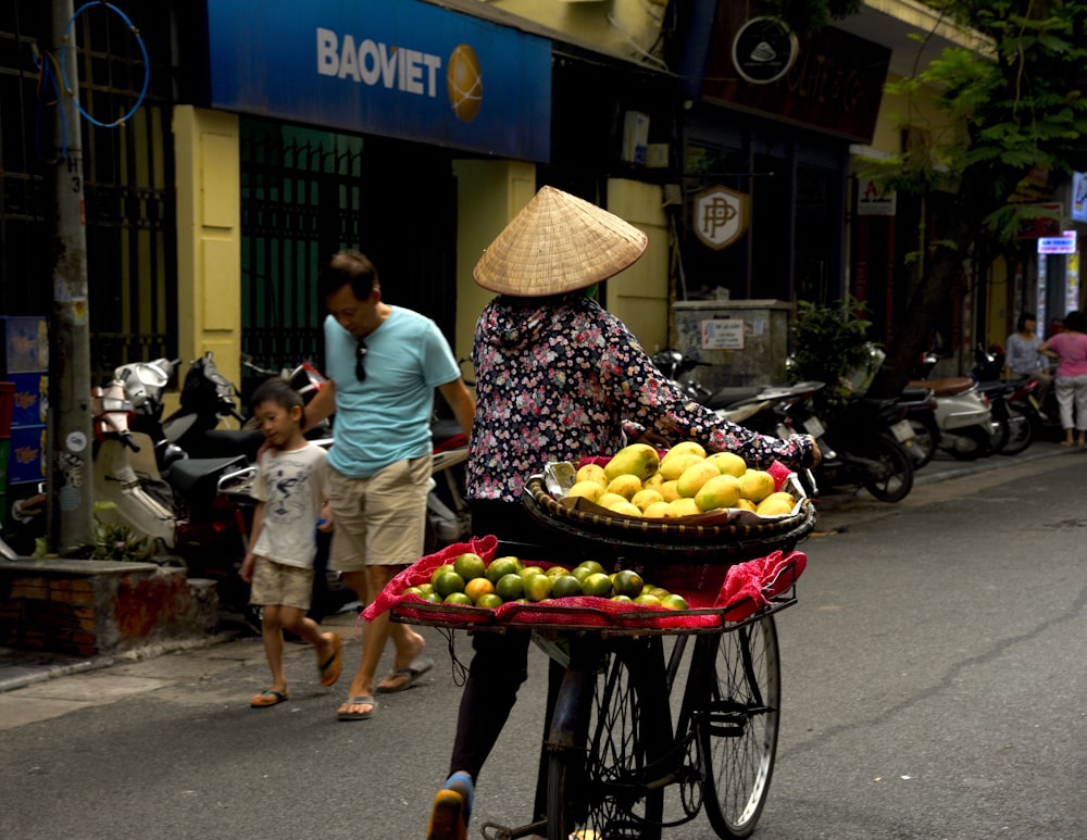 woman holding bicycle near Baomet storefront