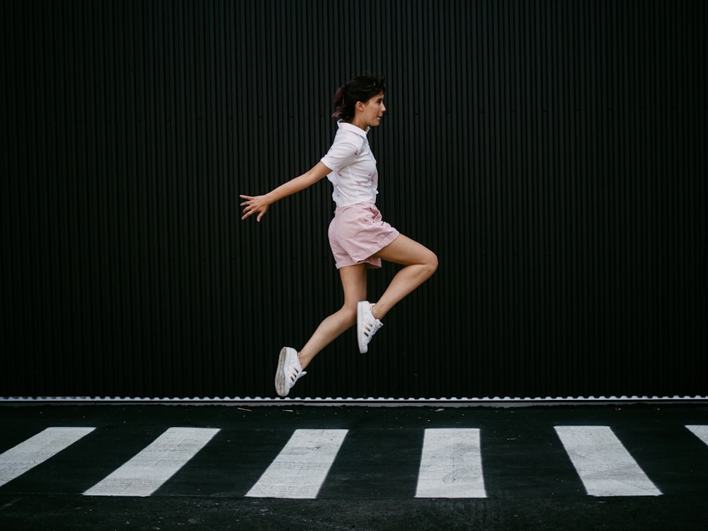 woman jumping on pedestrian lane