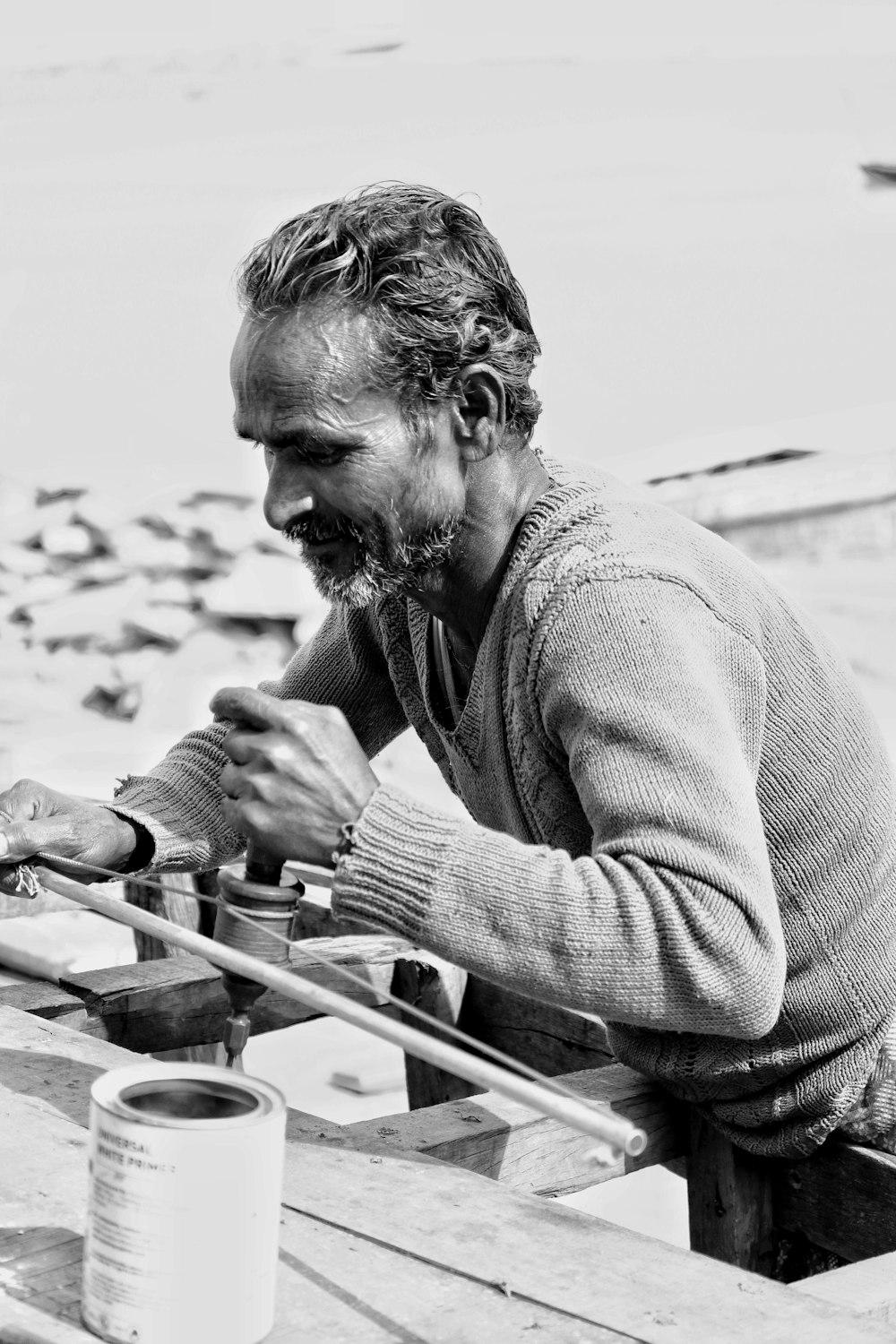 grayscale photography of man holding rod