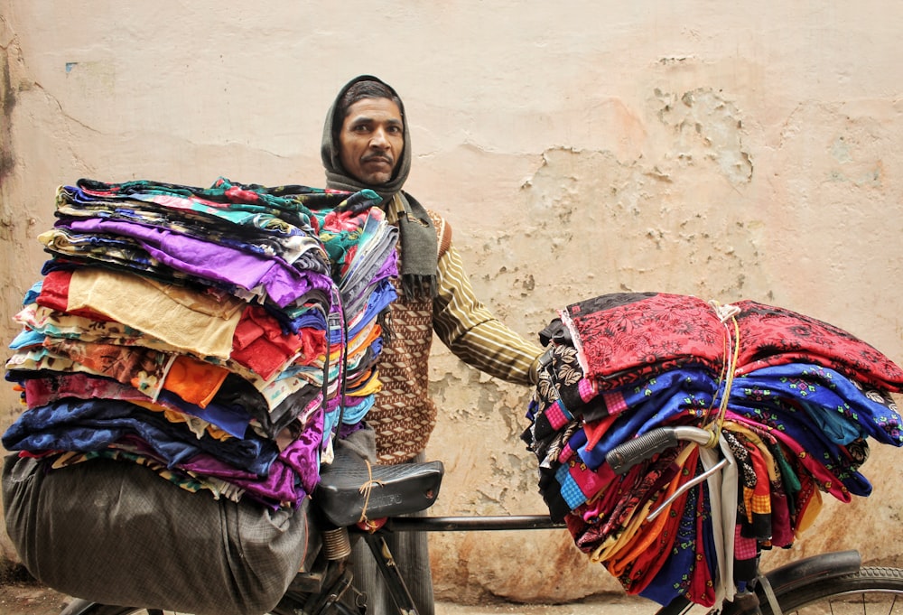 man standing beside bicycle with clothes