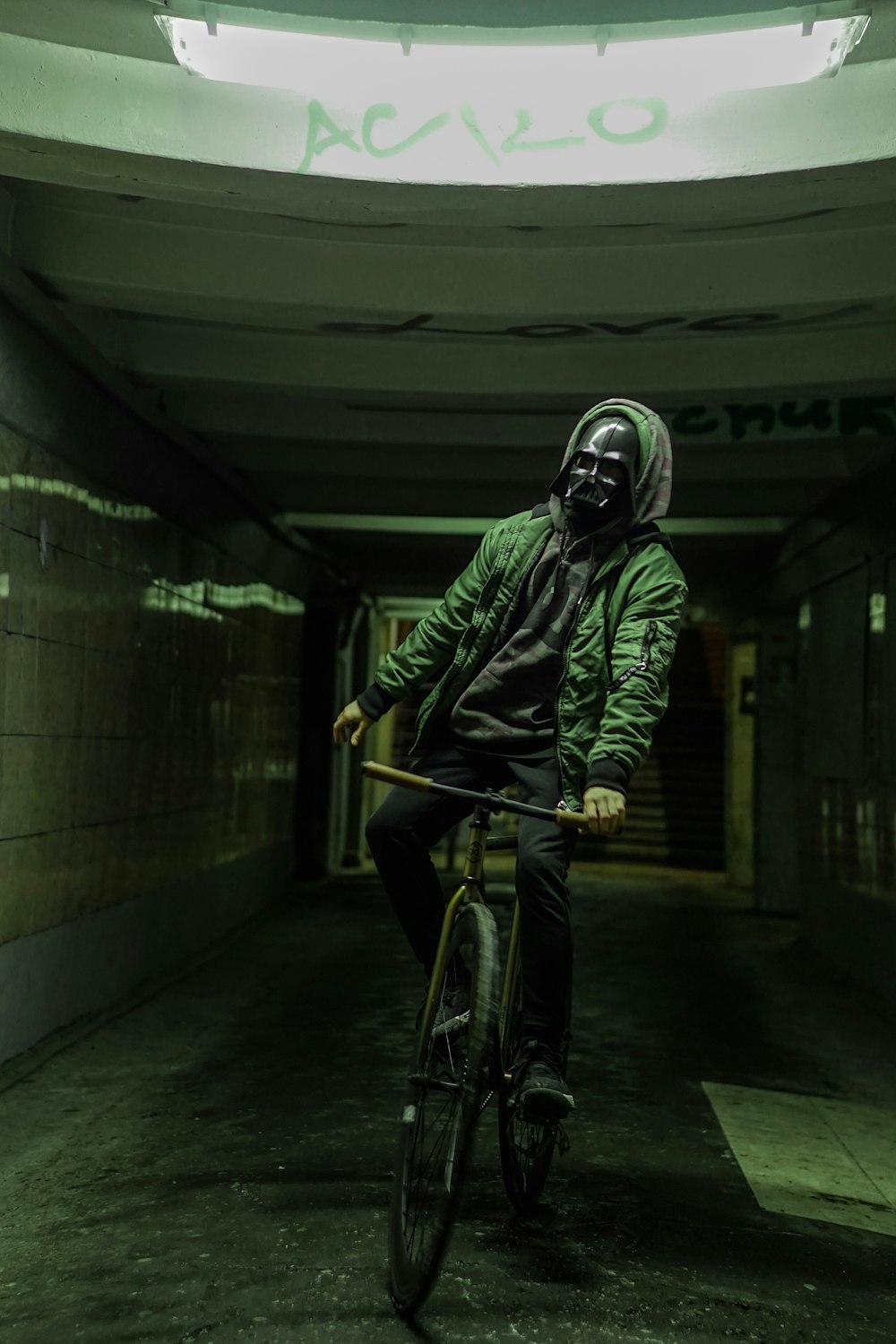 man in Dark Vader mask riding bicycle