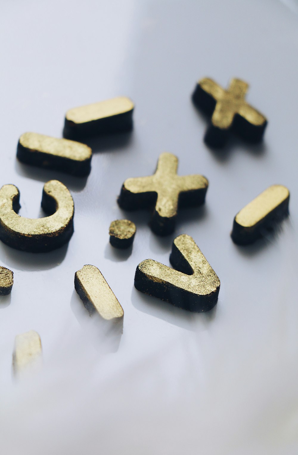 um close up de letras e números dourados em uma superfície branca