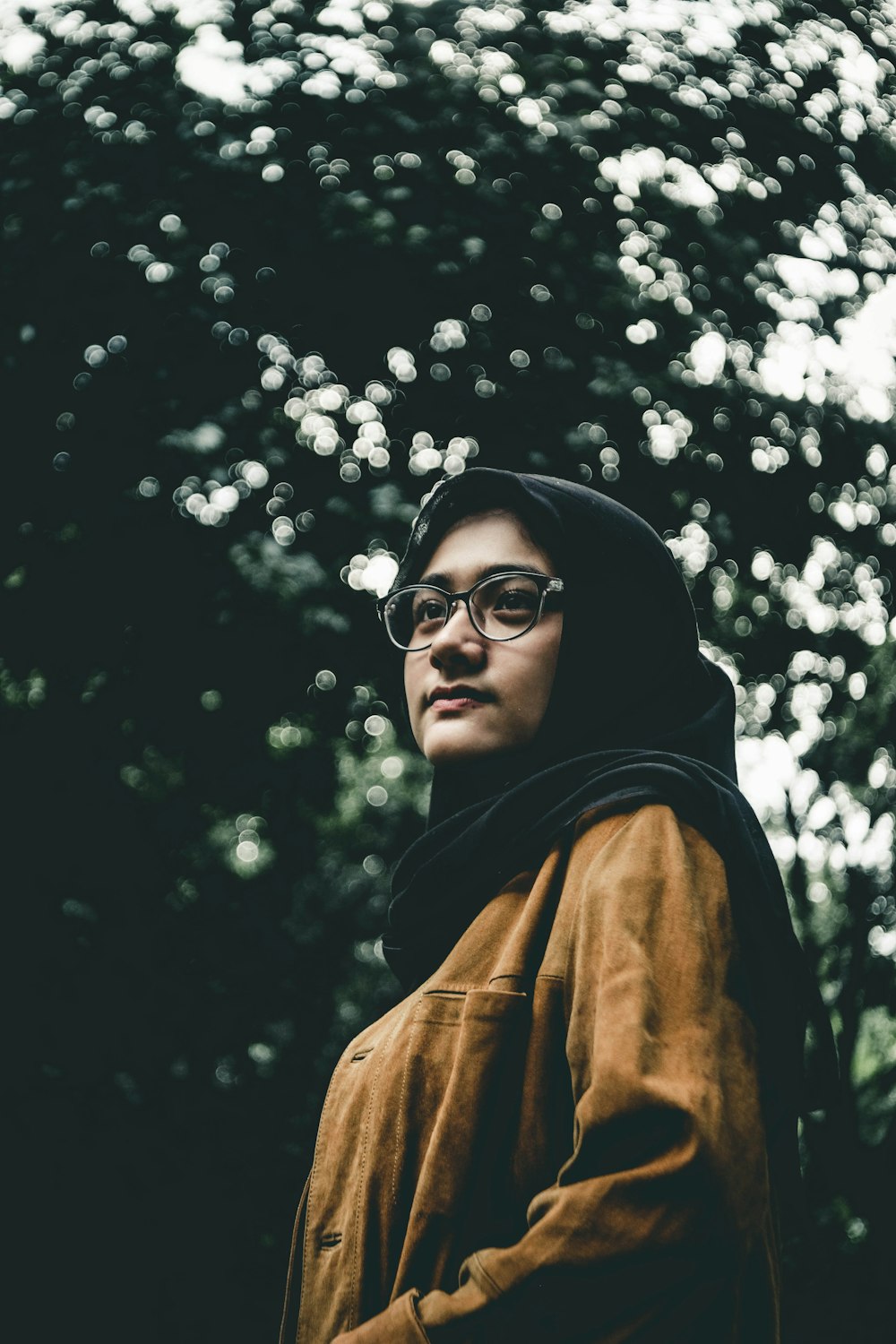 woman in black scarf and brown button-up long-sleeved top under trees