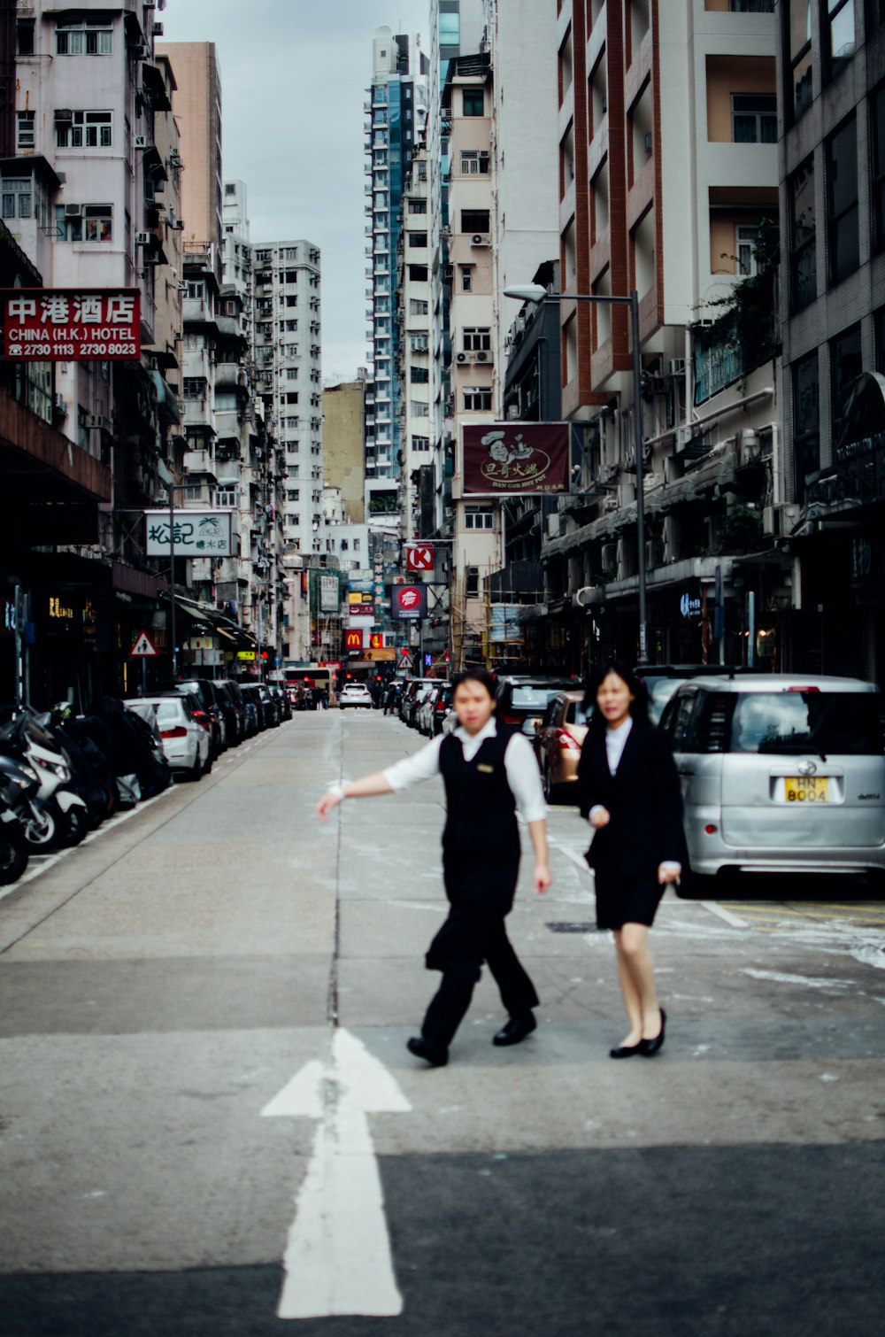 two women walks on street during daytime