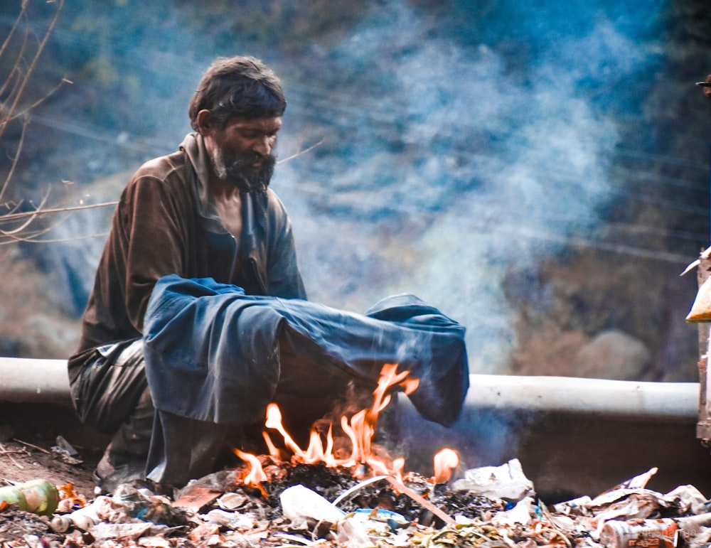 man heating clothing on fire