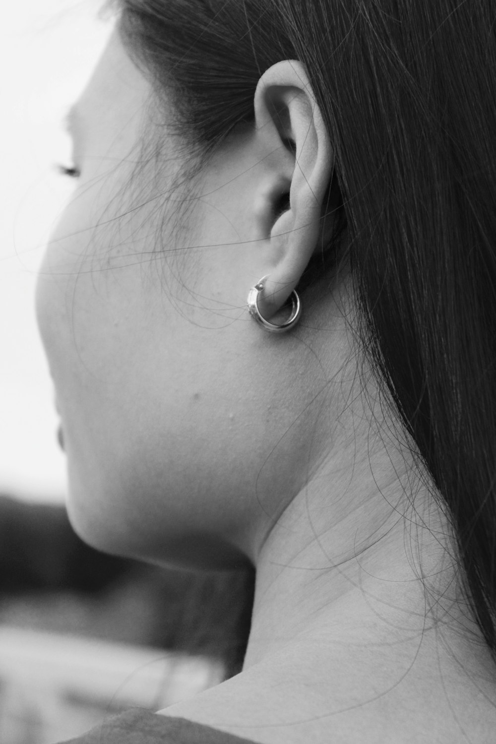 fotografia in scala di grigi di donna che indossa orecchino a cerchio