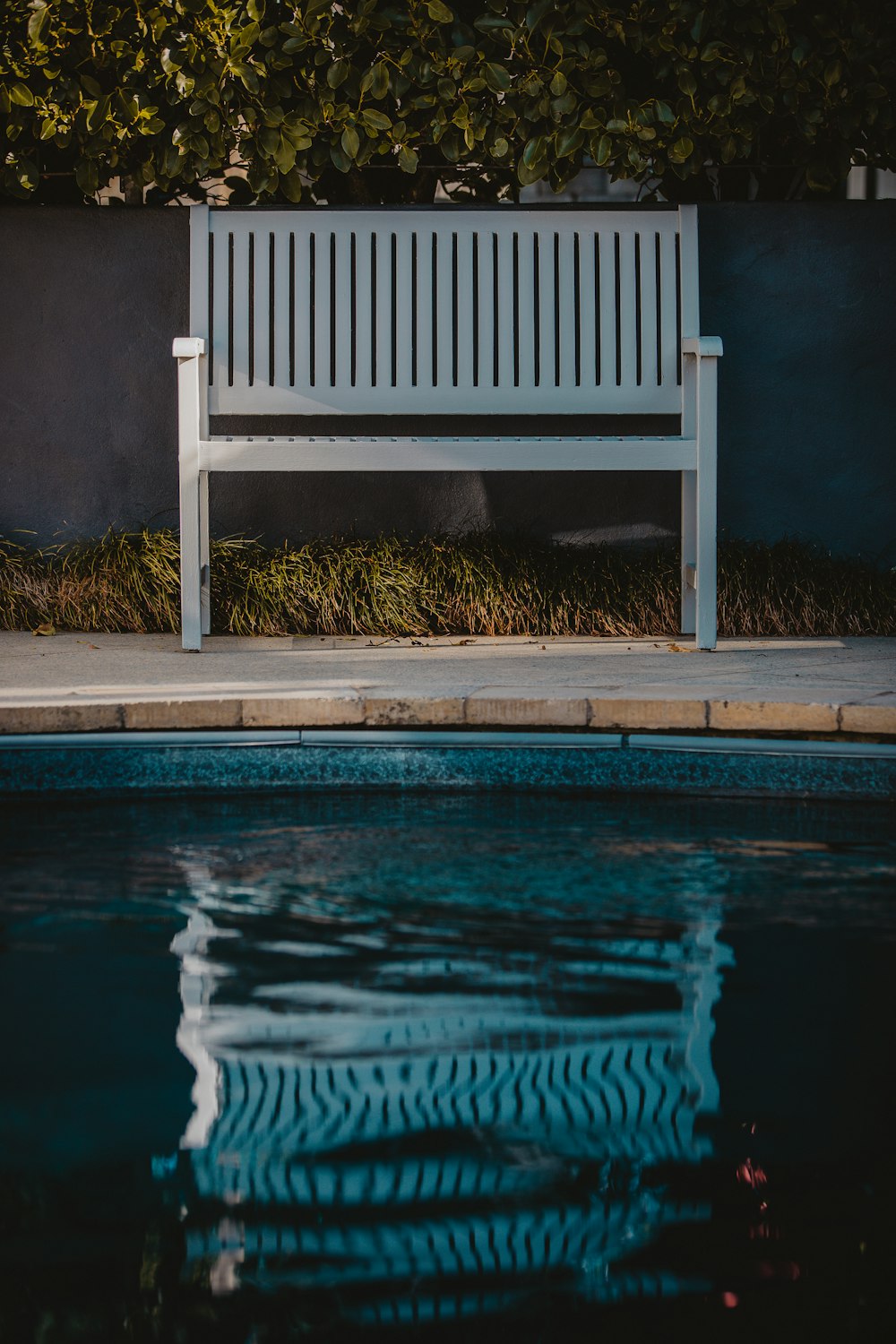 white wooden bench near outdoor pool