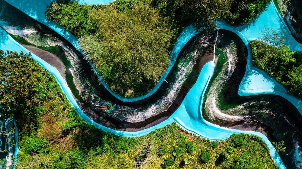 fotografia aérea do corpo de água cercado por árvores verdes durante o dia