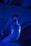 A close-up view of a metallic industrial pipe leading to a sprinkler or nozzle, illuminated by a blue light. The pipe has a shiny surface and connects to a red circular component mounted under a ceiling with a ribbed structure.