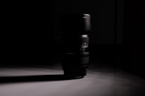 Close-up of a film camera lens reflecting a dramatic scene in deep shadows.