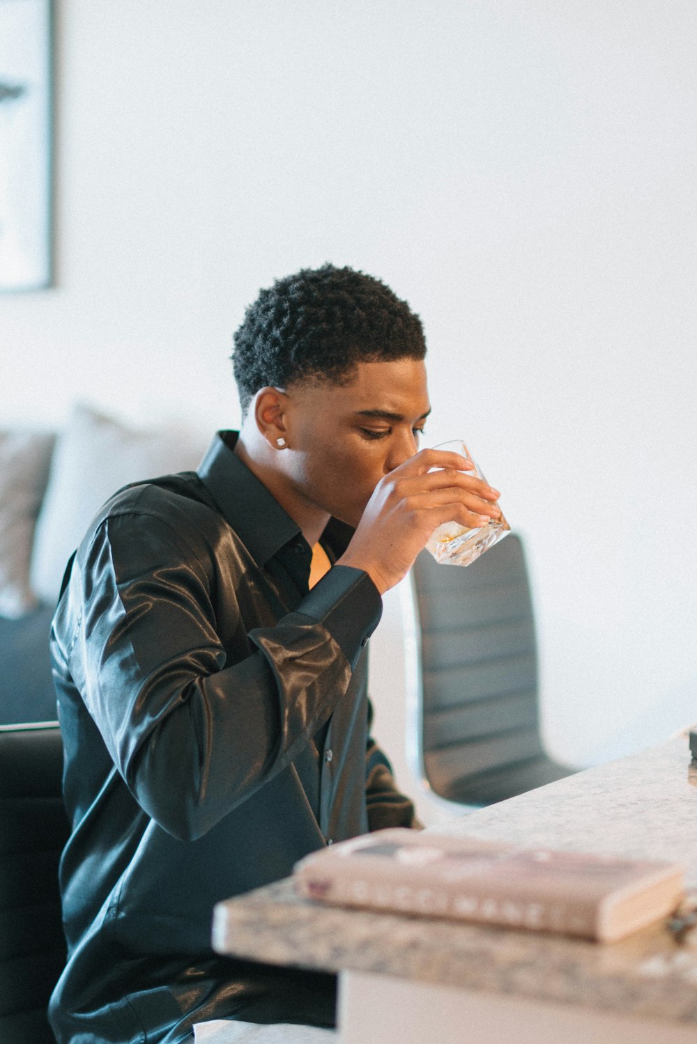 man wearing black jacket drinking water