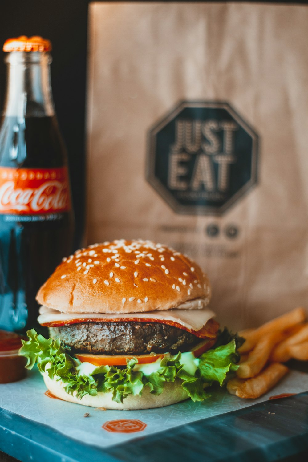 hamburger sandwich beside Coca-Cola bottle