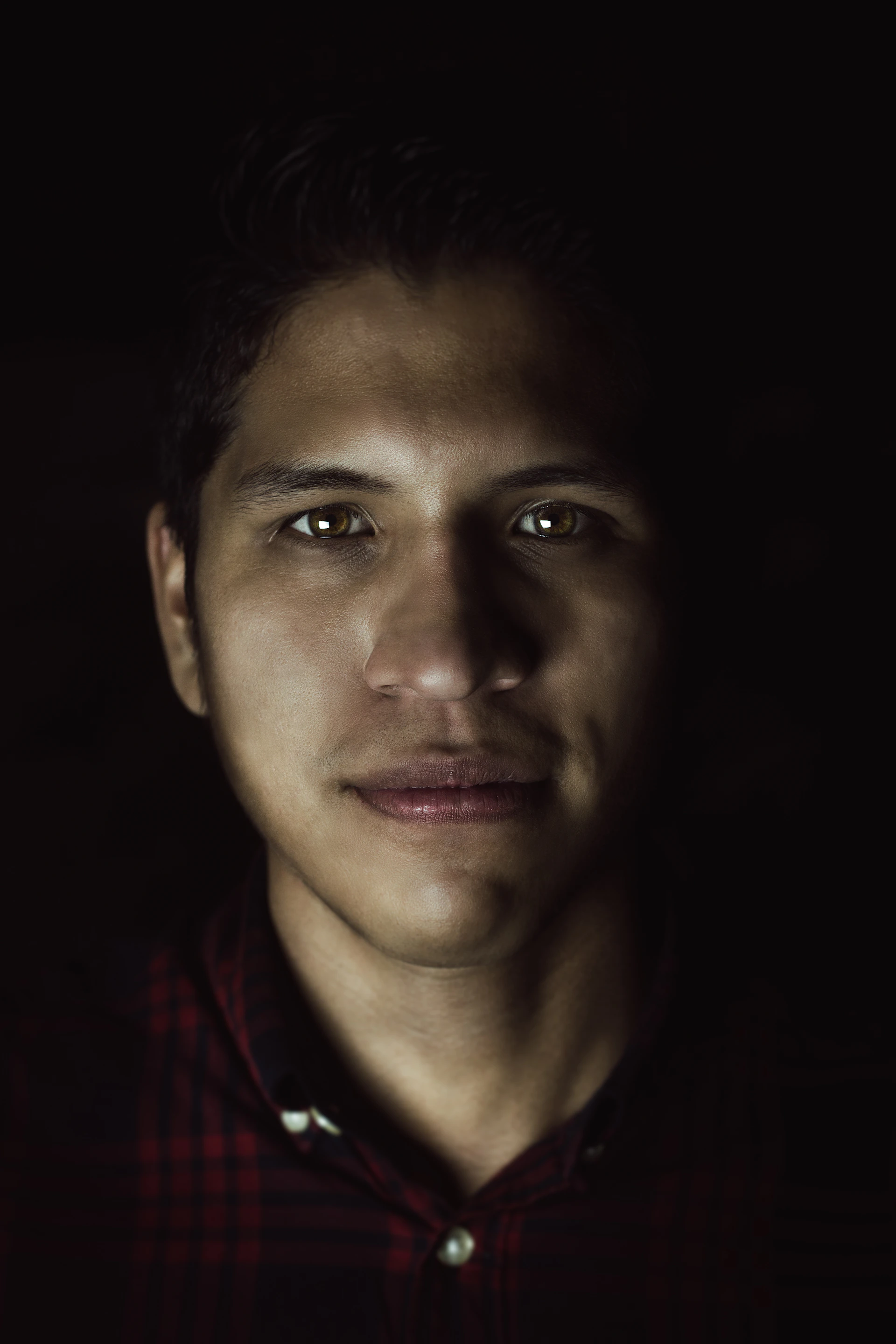 A close-up portrait of the referee, focused and calm, with the arena lights softly glowing behind.