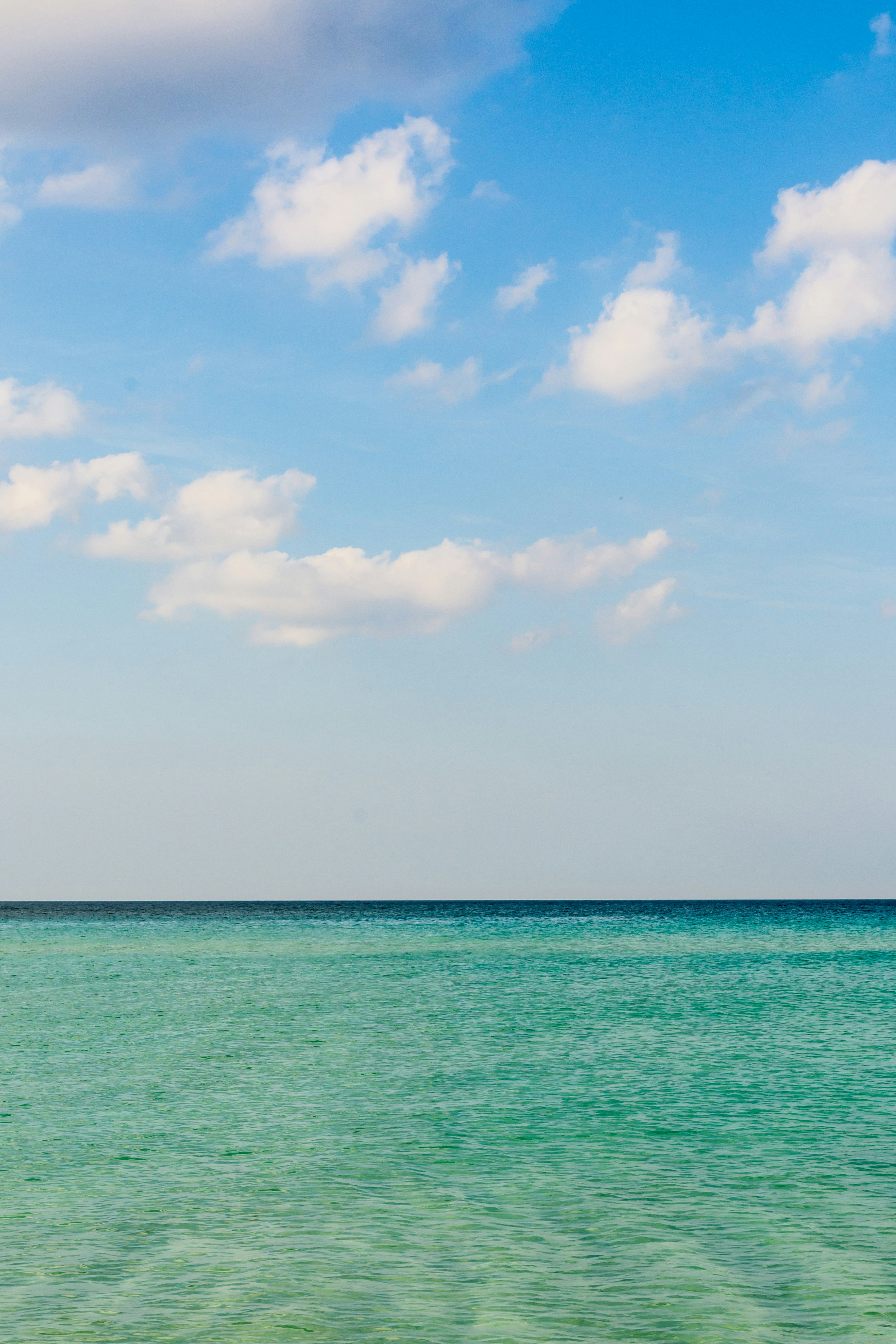 昼間の青い空と白い雲に青い海の写真 Unsplashで見つける青いの無料写真