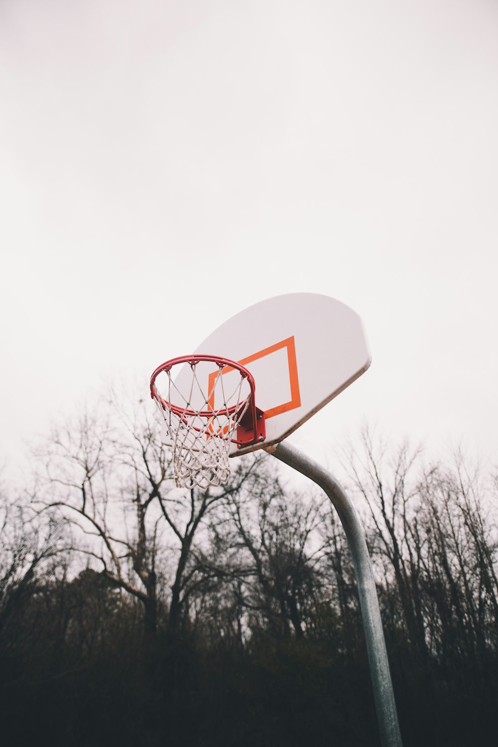 Tablero y aro de baloncesto blanco y naranja durante el día