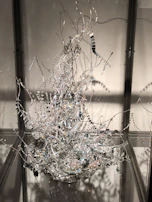 An intricate sculpture made from recycled metal pieces, displayed on a pedestal.
