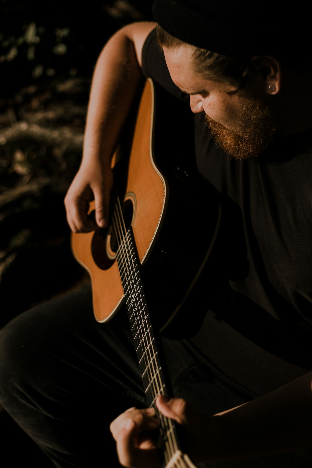 man in black tshirt playing guitar
