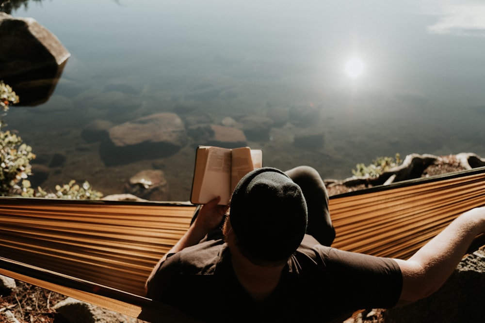 mam sitting on hammock reading book