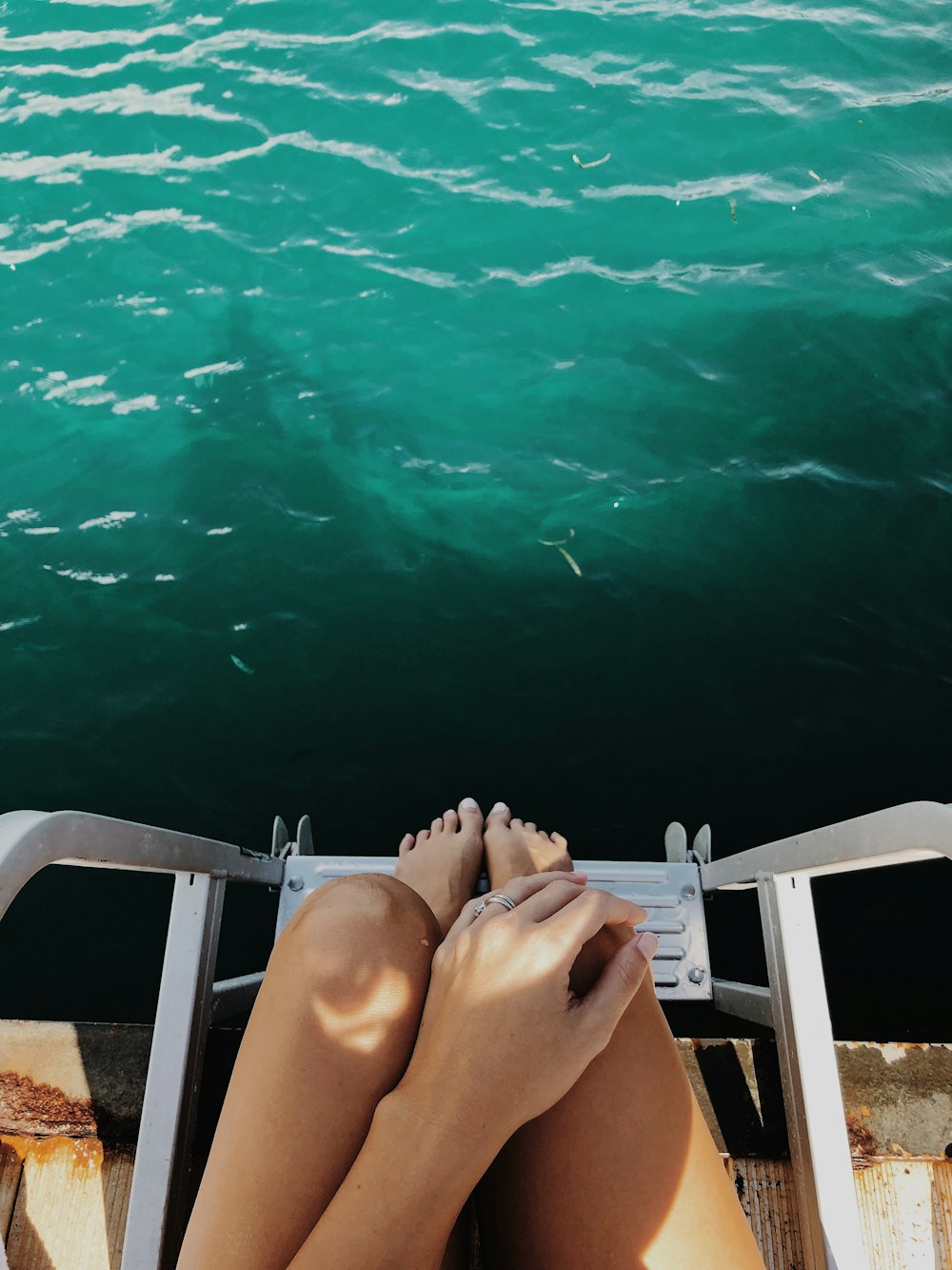 woman sitting on chair near body of water