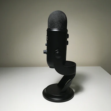 A sleek black and red microphone on a stand with soft golden lighting in the background.