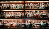 A well-lit bar shelf filled with colorful syrups and mixers.