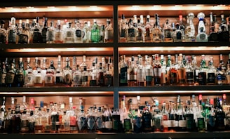 A well-lit bar shelf filled with colorful syrups and mixers.