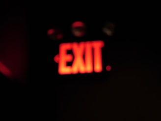 A close-up of a red alert sign glowing against a dark background symbolizing urgent investigative journalism.