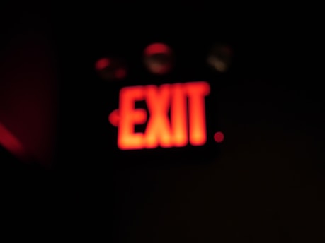 A close-up of a red alert sign glowing against a dark background symbolizing urgent investigative journalism.